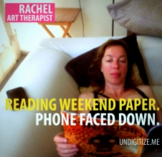 Reading Weekend Paper. Phone Faced Down.